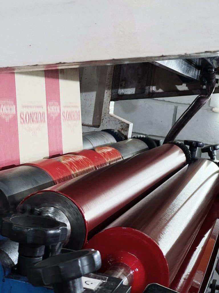 Imagem do cilindro de anilox transferindo tinta para o clichê de impressão e no papel kraft, no processo de flexografia